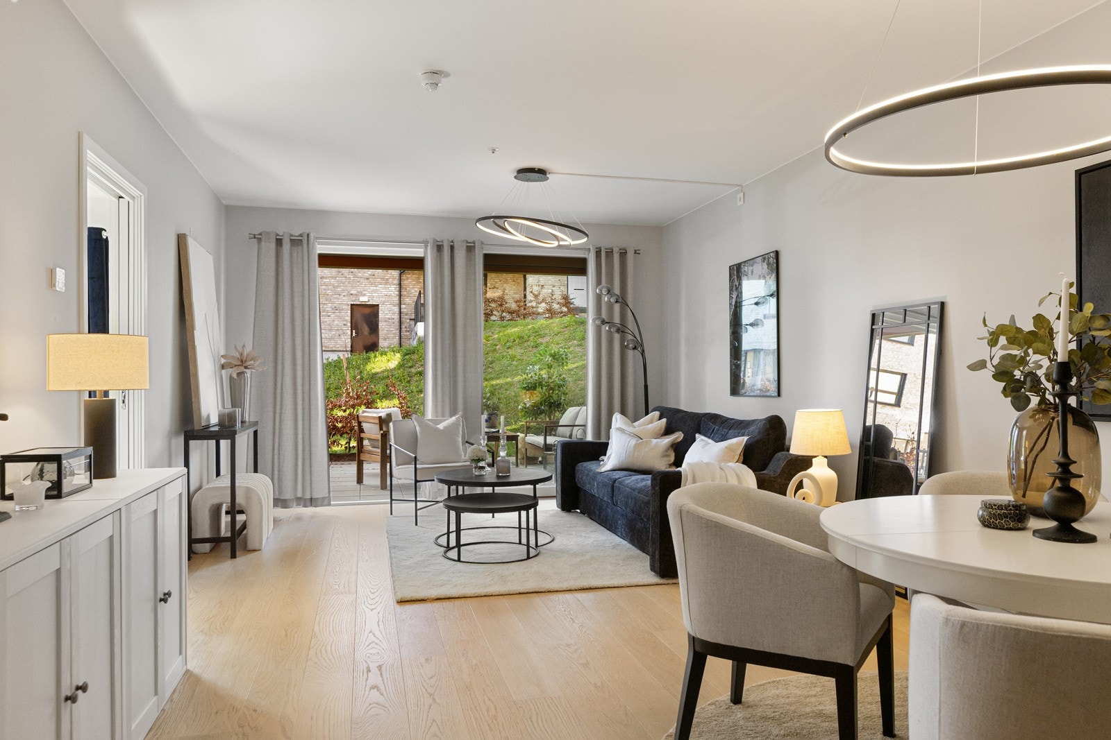 Stuen i leiligheten er romslig og flott opplyst med store vindusflater som gir rikelig med naturlig lys, og skaper en god atmosfære Galleribilde