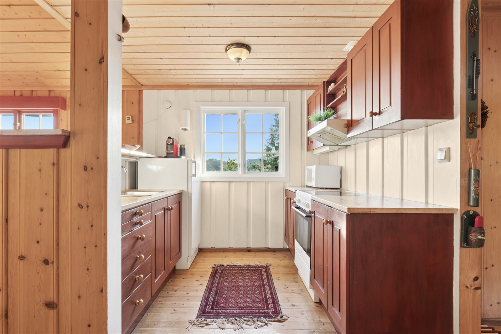 Plass for komfyr og kjøleskap. Kjøkkenet har godt med skap og benkeplass. Galleribilde