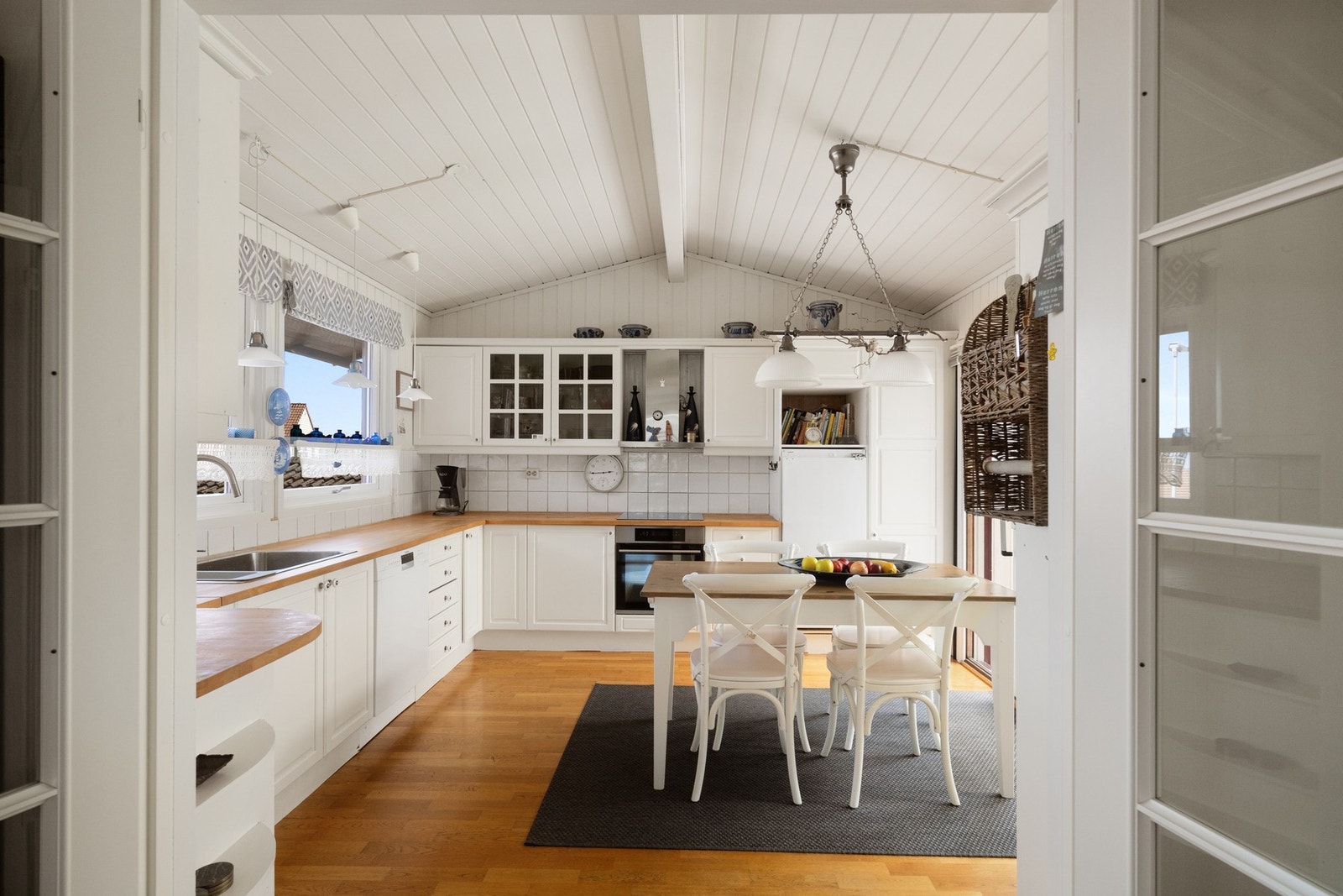 Lyst kjøkken med god benkeplass og rom for spisebord Galleribilde