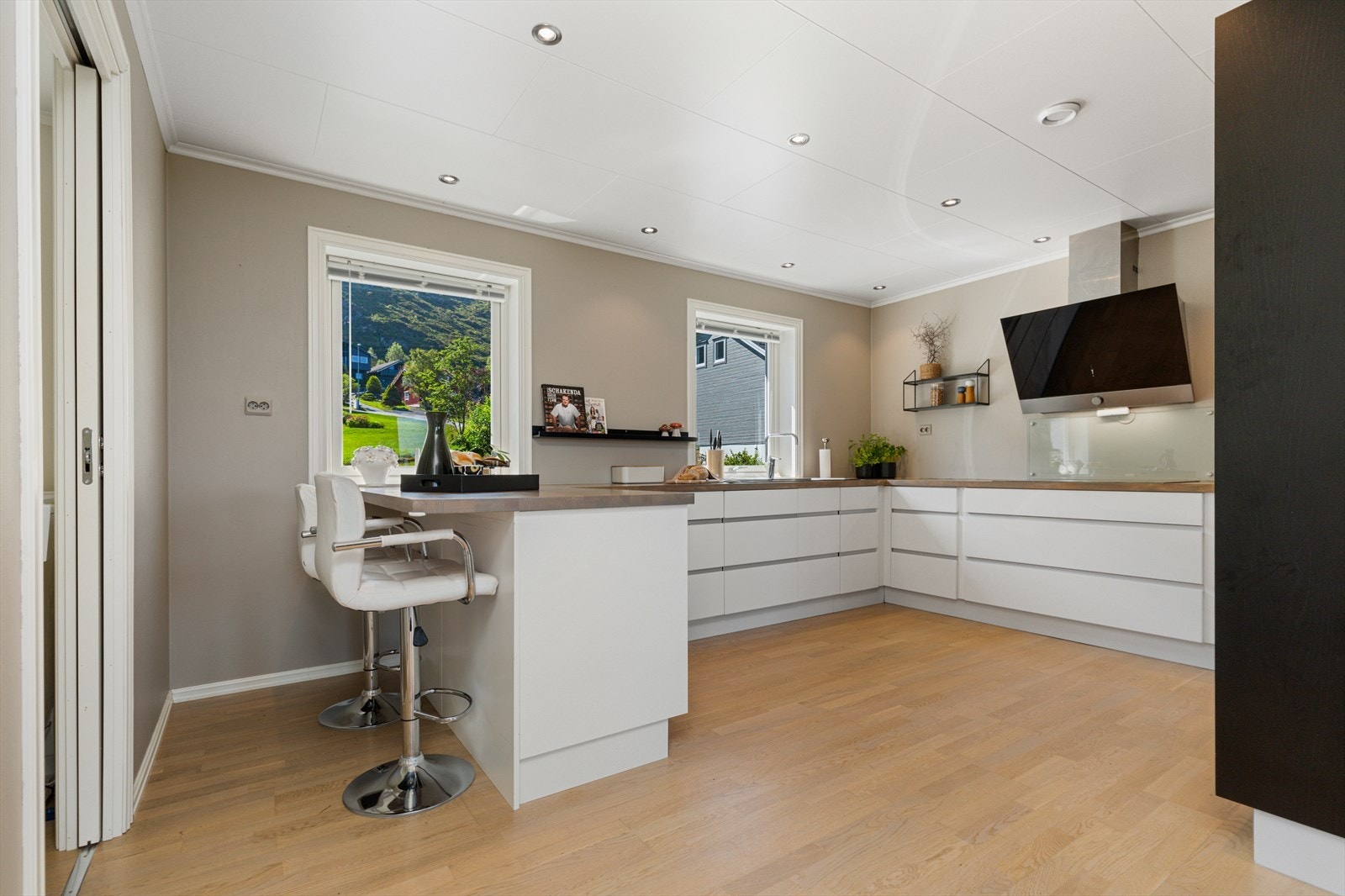 Kjøkkenet har glatte fronter, heltre benkeplate og nedfelt komposittvask. Utstyrt med integrerte hvitevarer, ventilator med utlufting, vannstoppsystem og komfyrvakt. Galleribilde