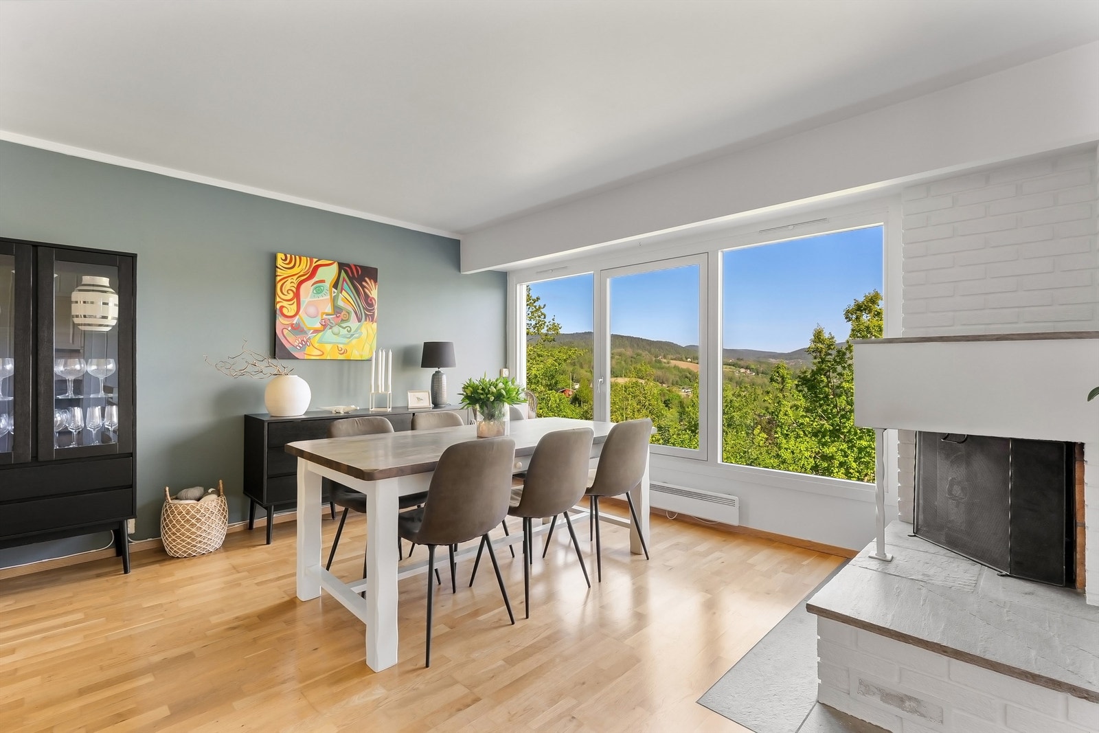 Romslig stue med peis og mye naturlig lys fra store vindusflater hvor også den nydelige utsikten kan nytes Galleribilde