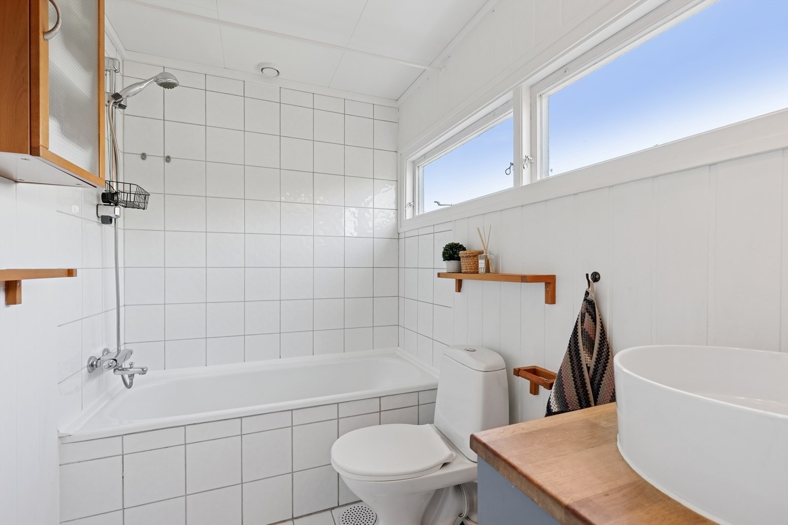 Eldre bad i 2. etasje med trepanel på veggene og fliser på gulv. Galleribilde