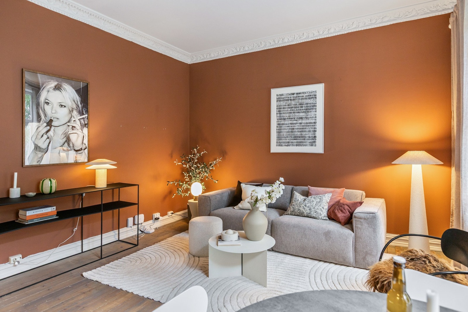 Boligens stue fremstår moderne og romslig. Rommet byr på en harmonisk miks av moderne stil og ærverdige detaljer som stukkatur og rosett. Galleribilde