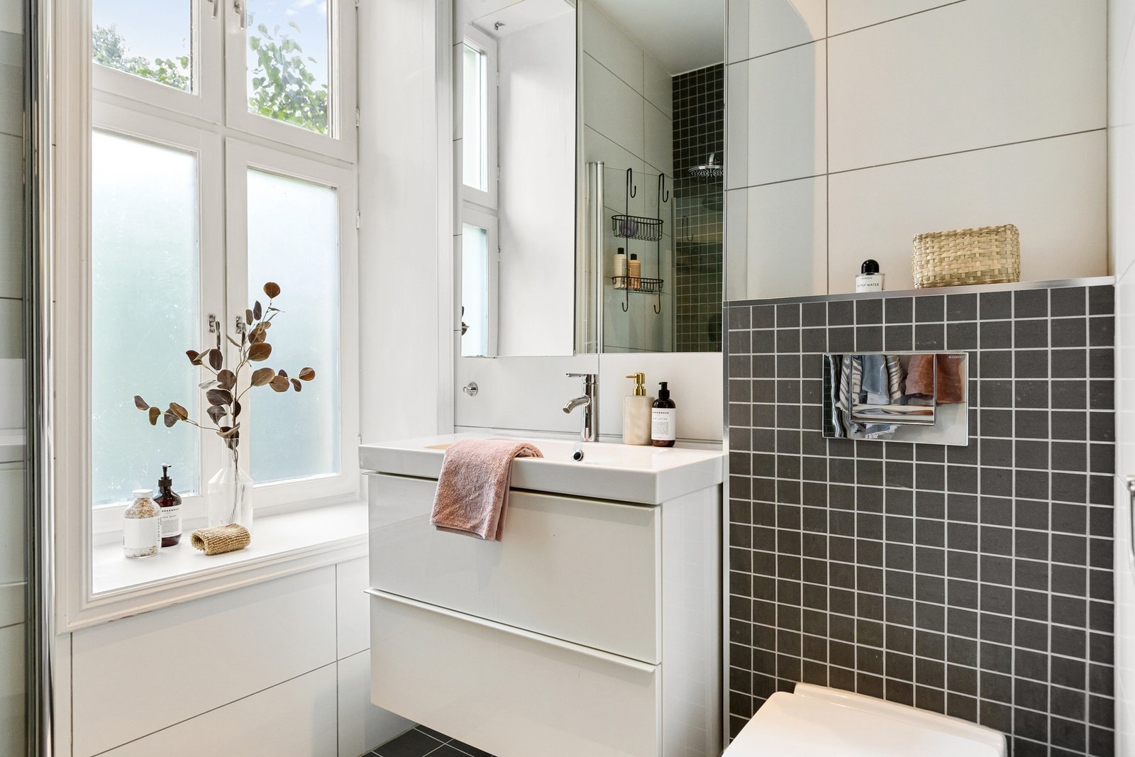 Badet byr på godt med oppbevaring i benkeskap, veggskap med speilfronter og hylleløsning på vegg. Galleribilde