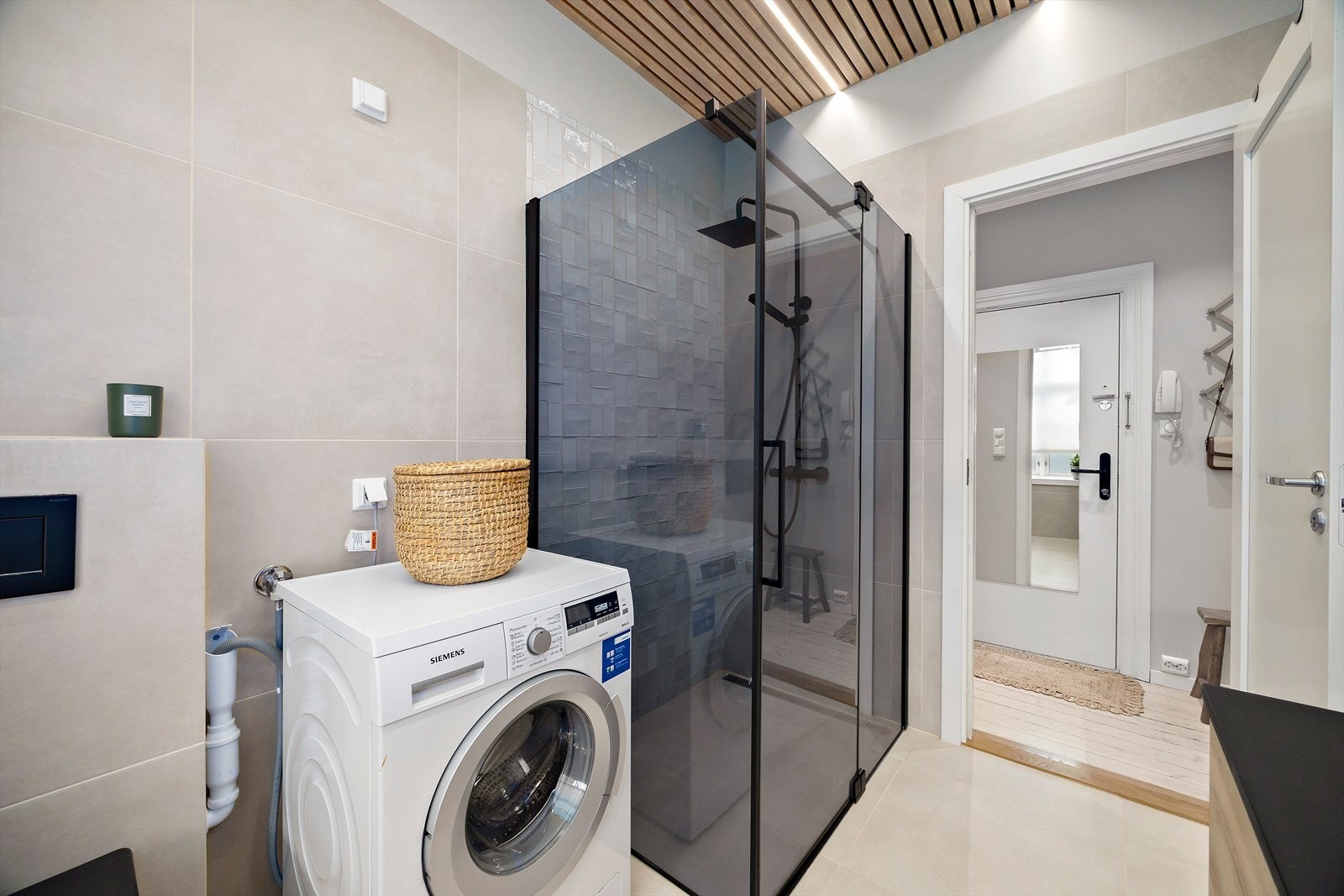 Praktisk og pent bad med dusjhjørne, vaskemaskin og gjennomtenkte løsninger fra 2023. Galleribilde