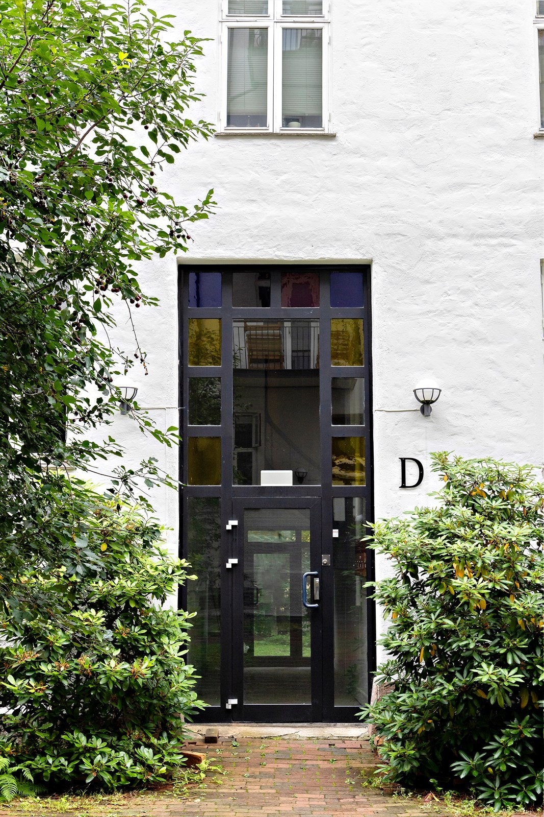 Velstelt fasade og moderne inngangsparti skjermet mot stille bakgård - trygt, pent og innbydende førsteinntrykk. Galleribilde