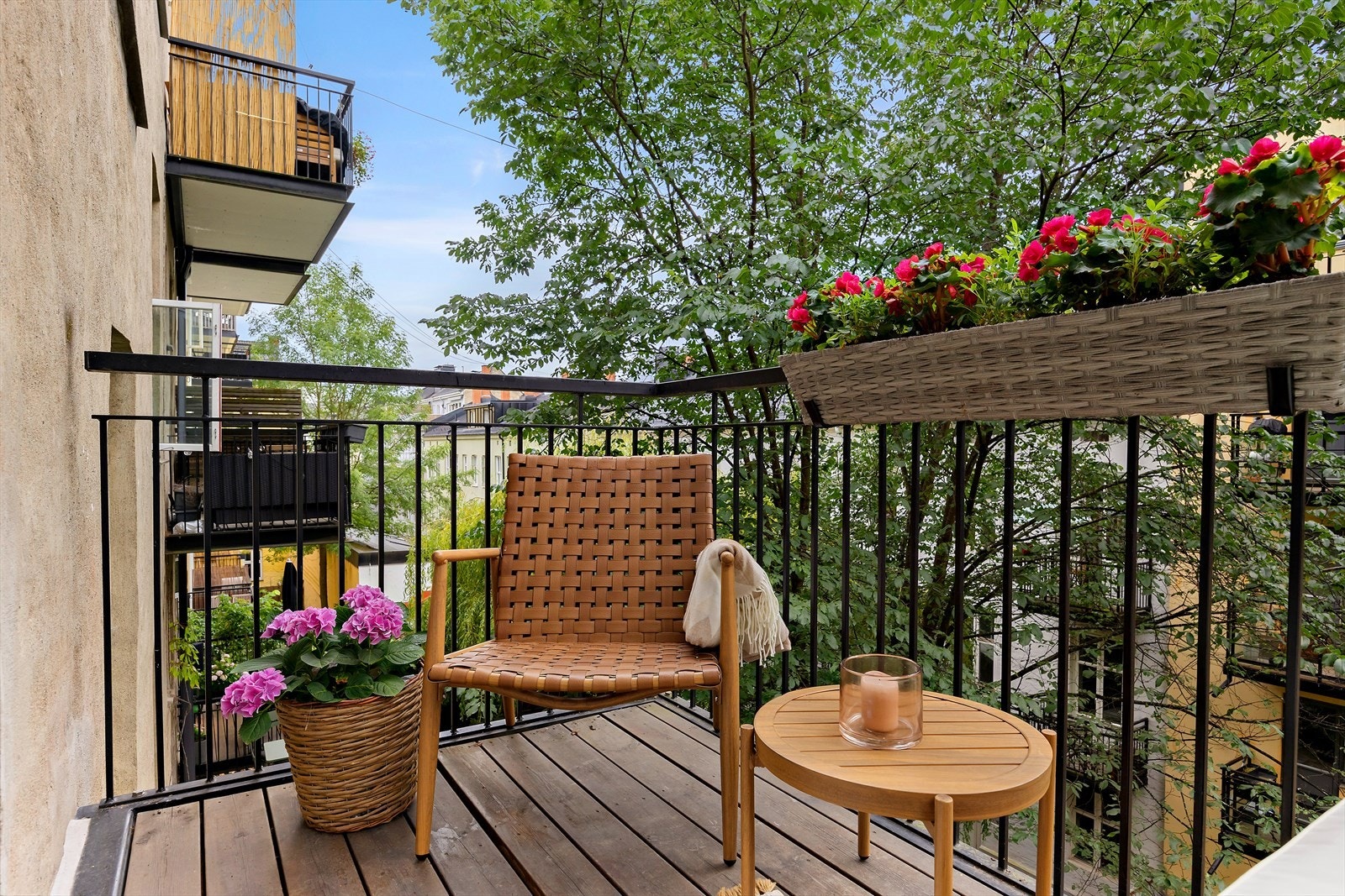 Vestvendt balkong med ettermiddagssol og grønn utsikt mot skjermet bakgård. Galleribilde