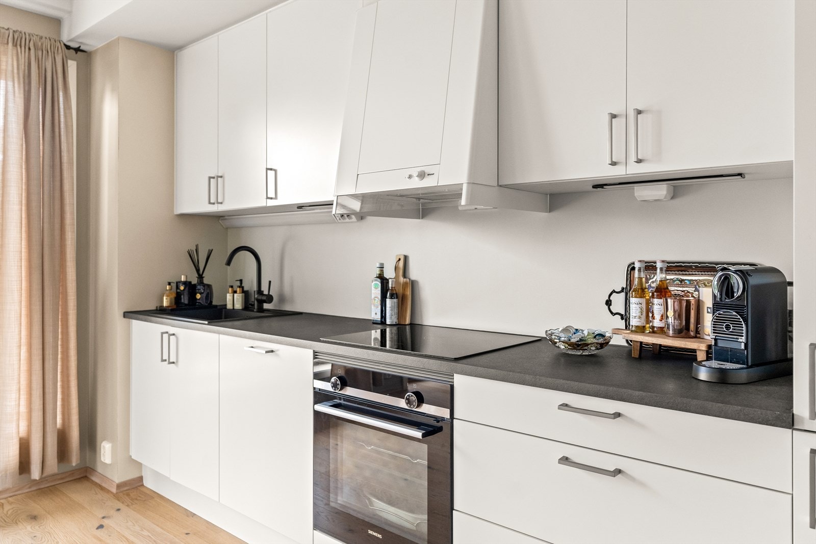 Kjøkkenet er stilrent med mye skap, skuffer og benkeplass, i tillegg til integrerte hvitevarer. Galleribilde