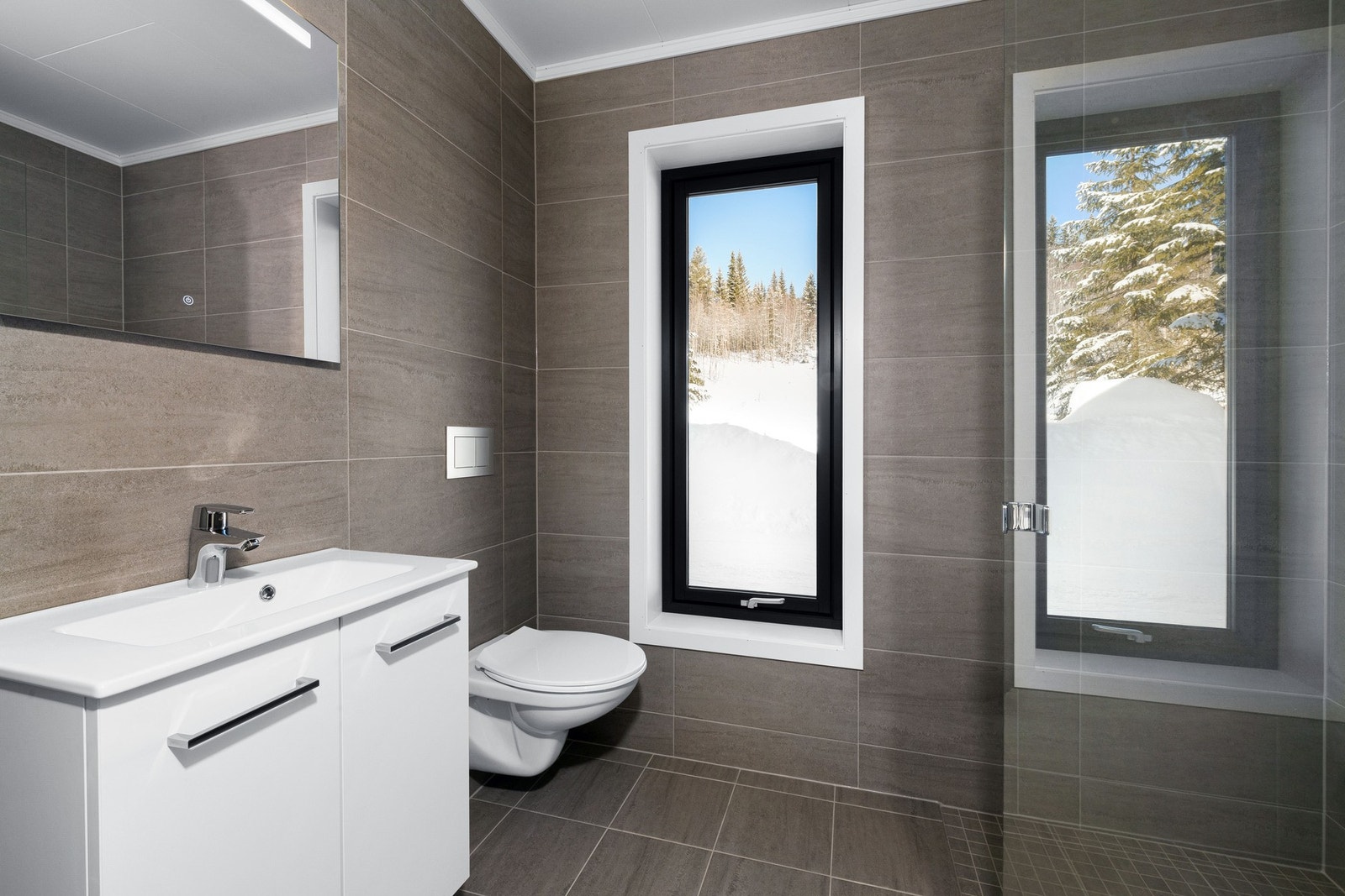 Et vindu bidrar til naturlig lys inn på badet. Galleribilde