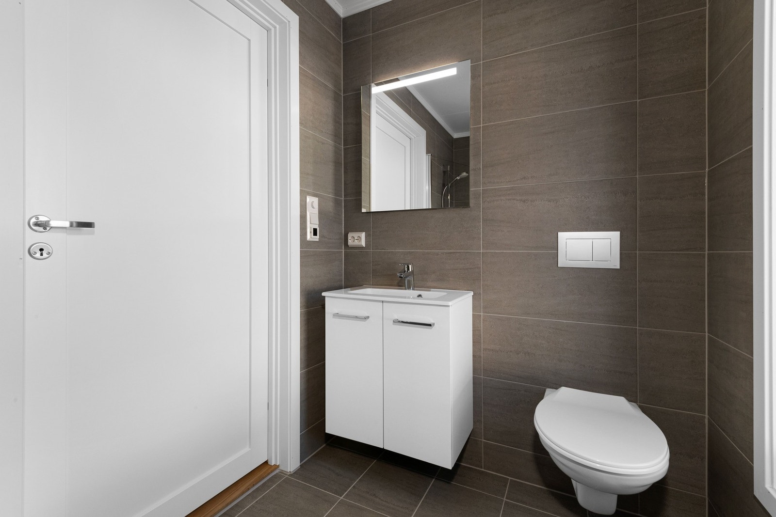 På badene leveres det hvit baderomsinnredning med heldekkende servant, underskuffer og tilhørende speil. Galleribilde