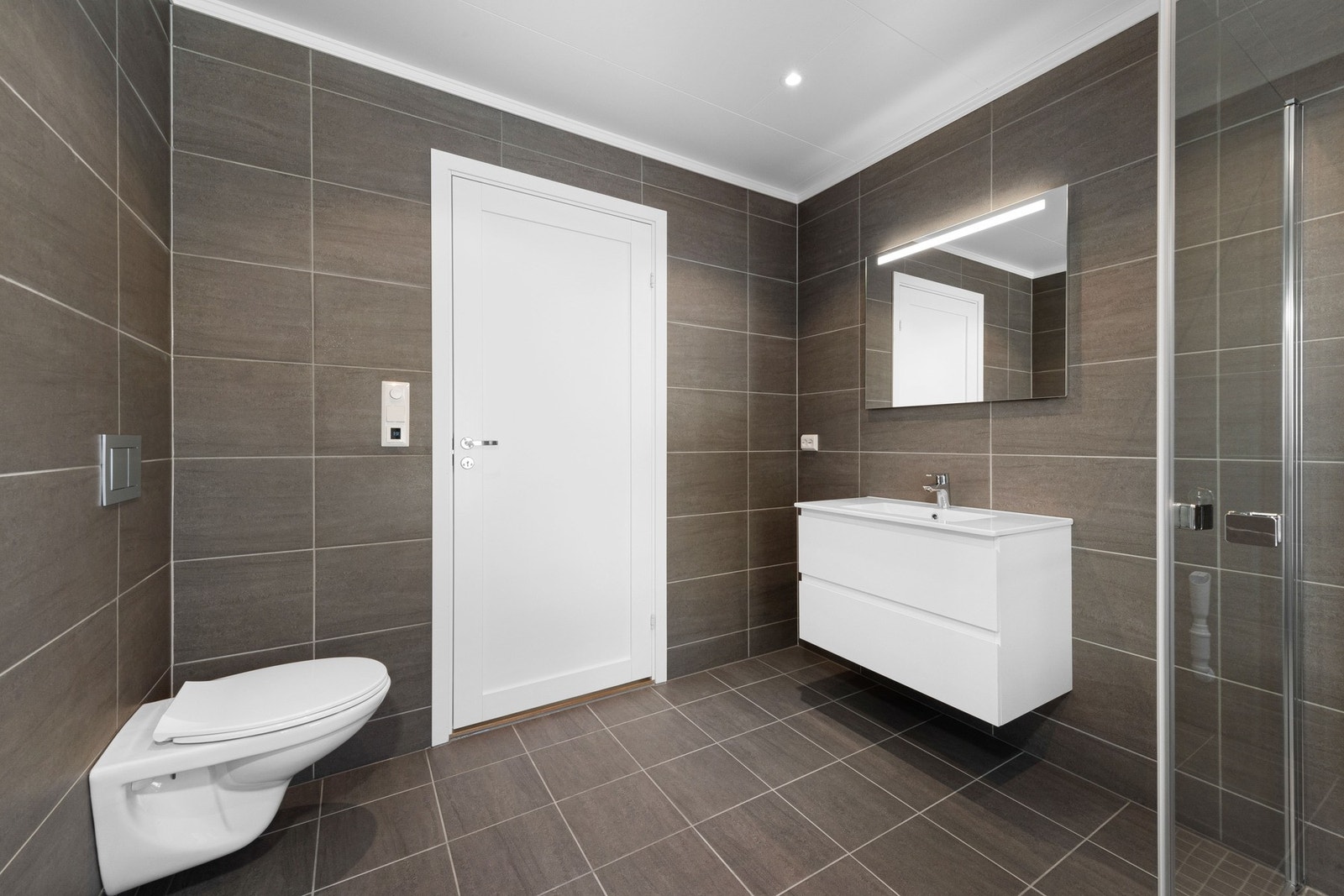 Badene får pene fliser fra Norfloor på gulv og vegger (medium grey). Galleribilde