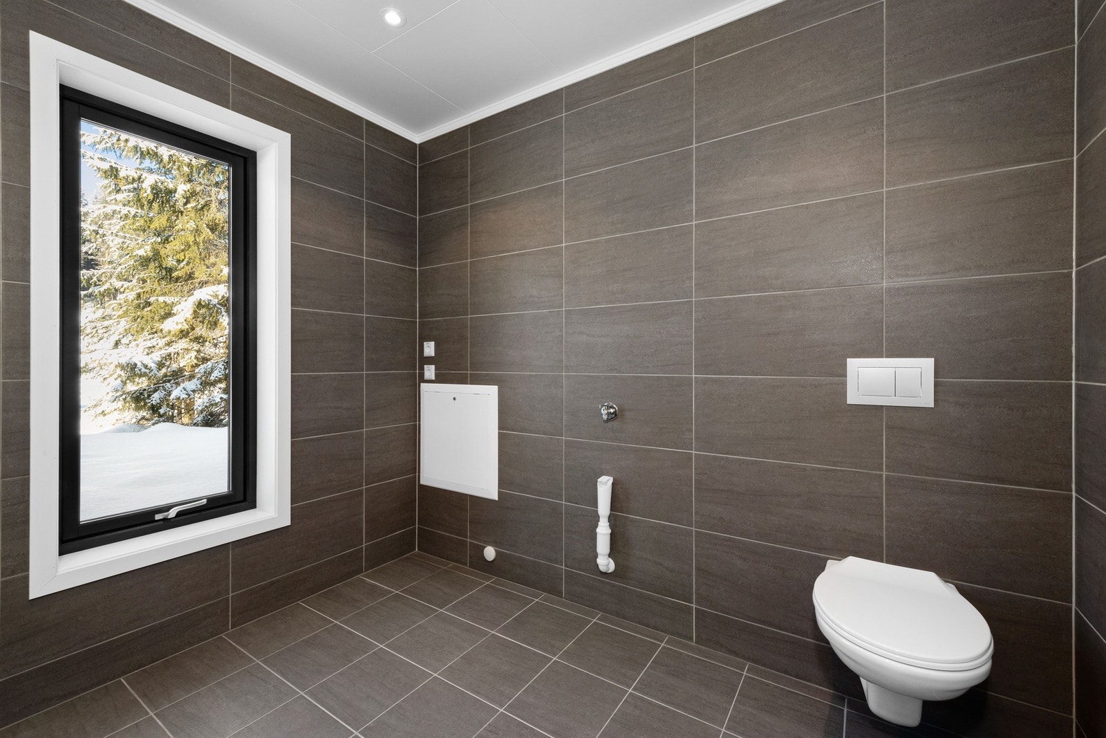 Toalettene monteres på vegg. I tillegg får hvert bad dusjhjørne med innfellbare dusjvegger, og rommene får selvfølgelig også gulvvarme og downlights. Galleribilde