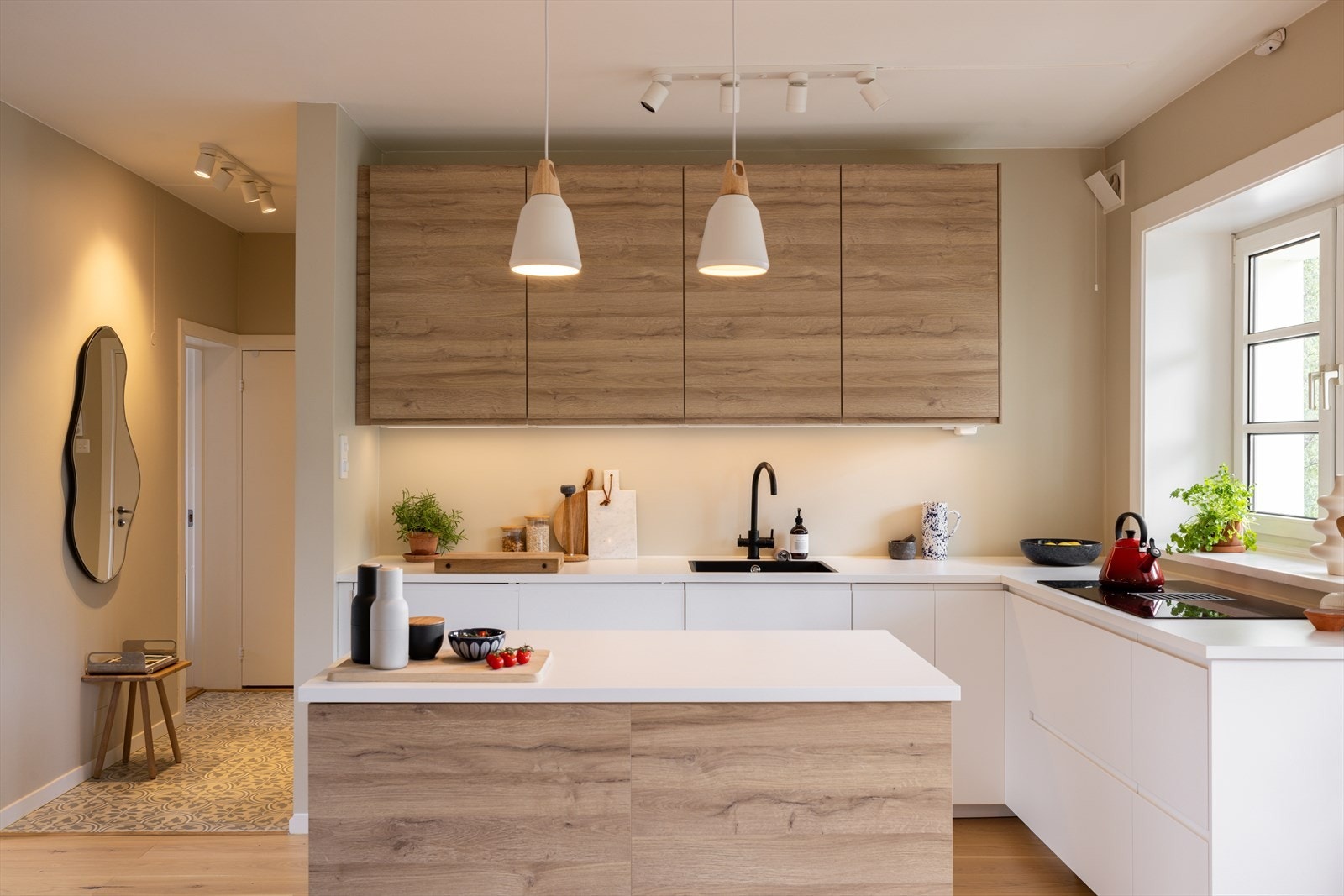 Lekkert og moderne kjøkken som har en åpen og sosial løsning til spisesone Galleribilde