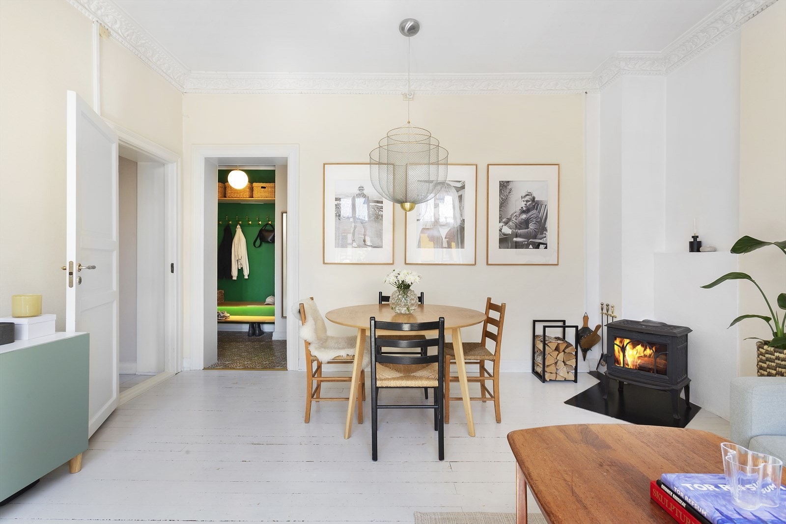 Stue med vedovn, takrosetter og god plass til både sofakrok og spisebord - perfekt for hyggelige kvelder hjemme. Galleribilde