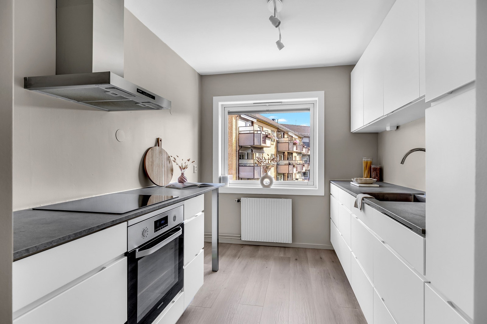 Kjøkkenet er praktisk plassert i eget rom. Moderne og tidløs innredning fra Kvik med glatte fronter - montert i 2018. Galleribilde