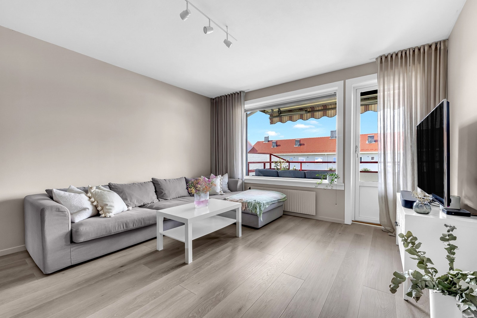 Lys og innbydende stue med store vindusflater som slipper inn rikelig med lys! Det er montert plissègardiner fra Kjells markiser for solskjerming og innsyn. Galleribilde