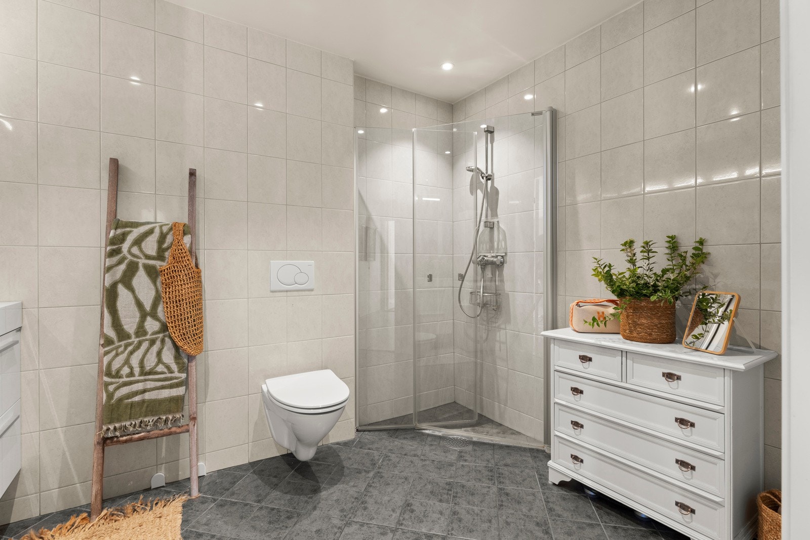 Innredningen består av et veggmontert toalett, en dusjplass med inn- og utadslående dusjvegger, samt en moderne servant med ettgreps blandebatteri i stilfull lys innredning. Galleribilde