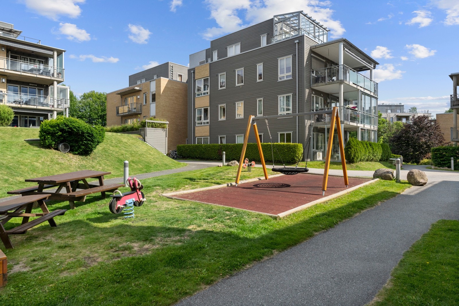 Fellestomten er flott opparbeidet med asfalterte gang-/adkomstarealer, lekeplasser, grøntarealer, sittegrupper, plener og beplantinger og felles gjesteparkering. Galleribilde