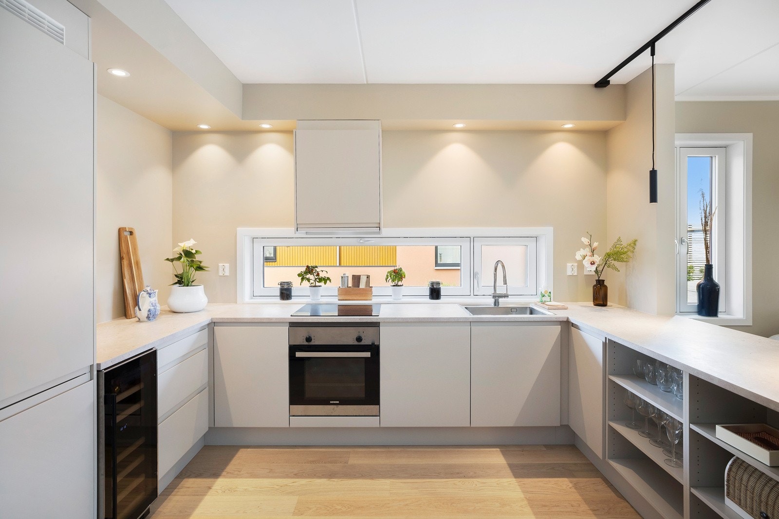 Kjøkkeninnredningen har samme duse farger som på veggene og er i moderne stil med glatte fronter. Galleribilde