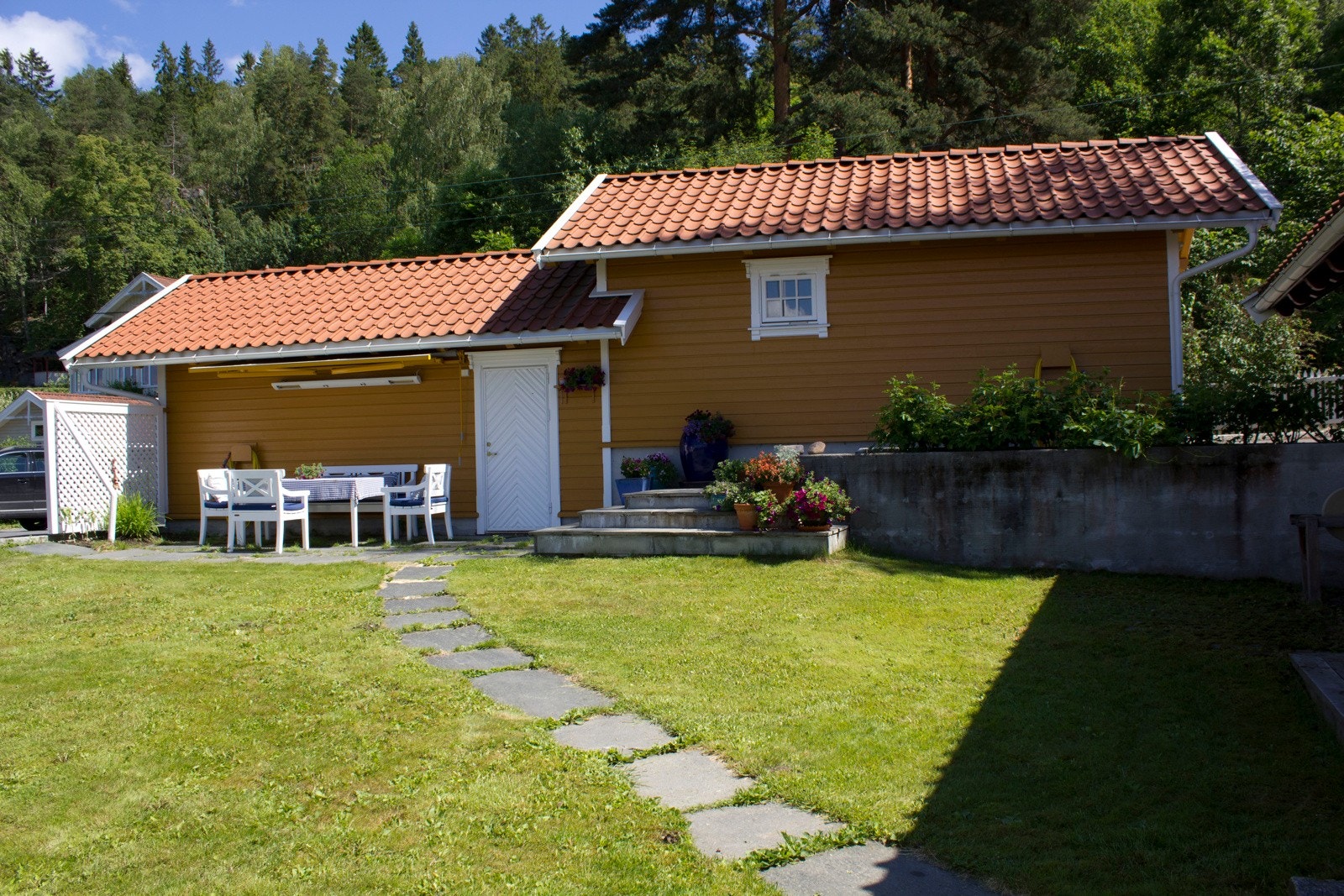 Garasjen skjermer for innsyn til eiendommen og gir en lun og fin krok hvor det er veldig fint å sitter på varme sommerdager. Galleribilde