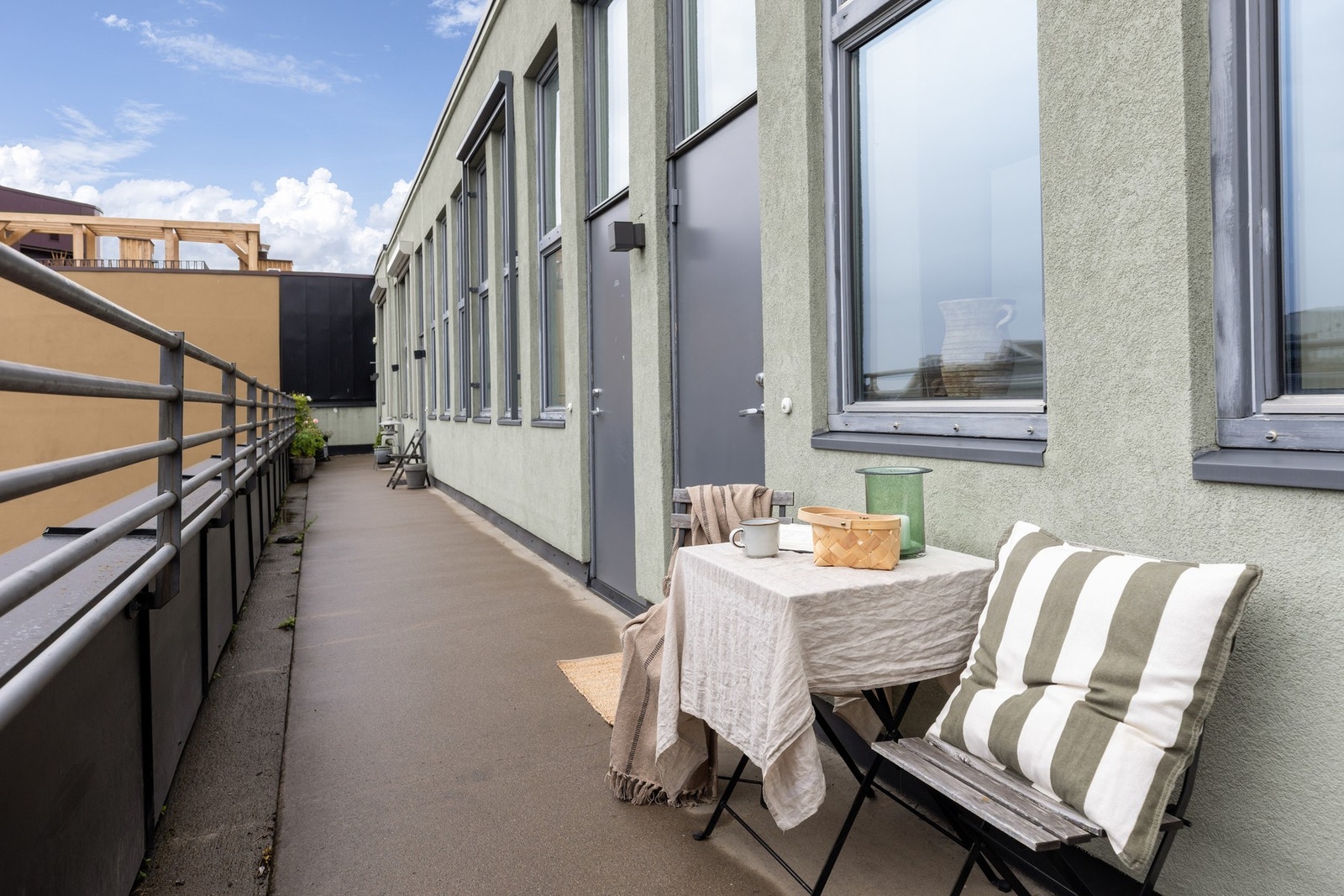 Svalgang på utsiden med morgensol - her også innredet med hyggelig frokostbord. Galleribilde