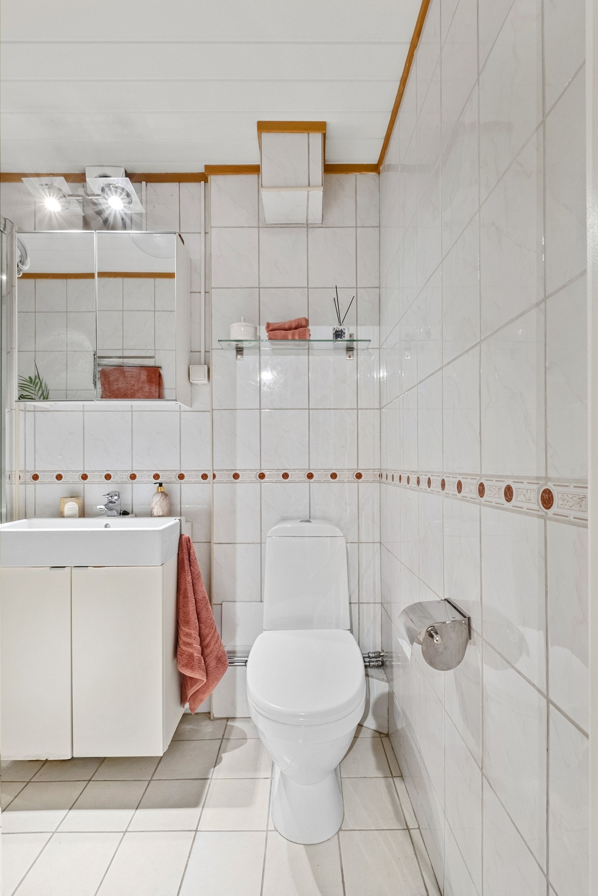 Badet er innredet med servant med underskap, dusjhjørne med glassdører, toalett og speilskap med god oppbevaringsplass. Galleribilde