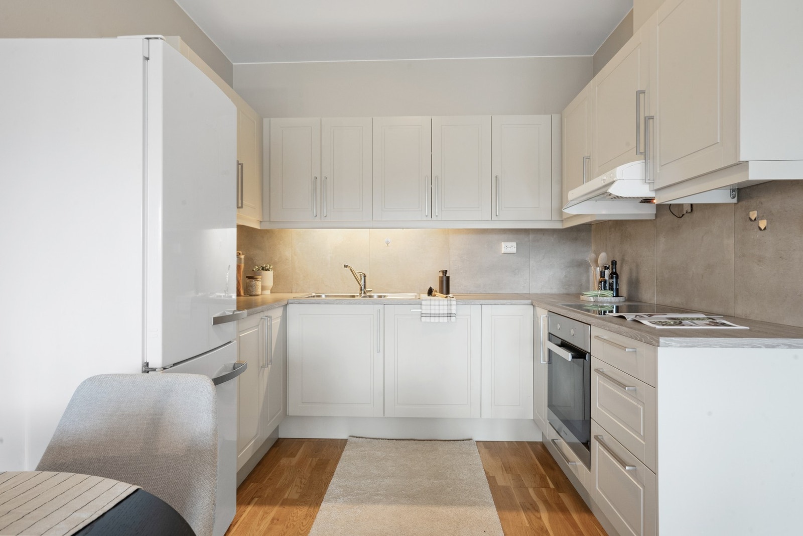 Kjøkken med fliser mellom benk og overskap, laminat benkeplate og godt med skap- og benkeplass. Galleribilde