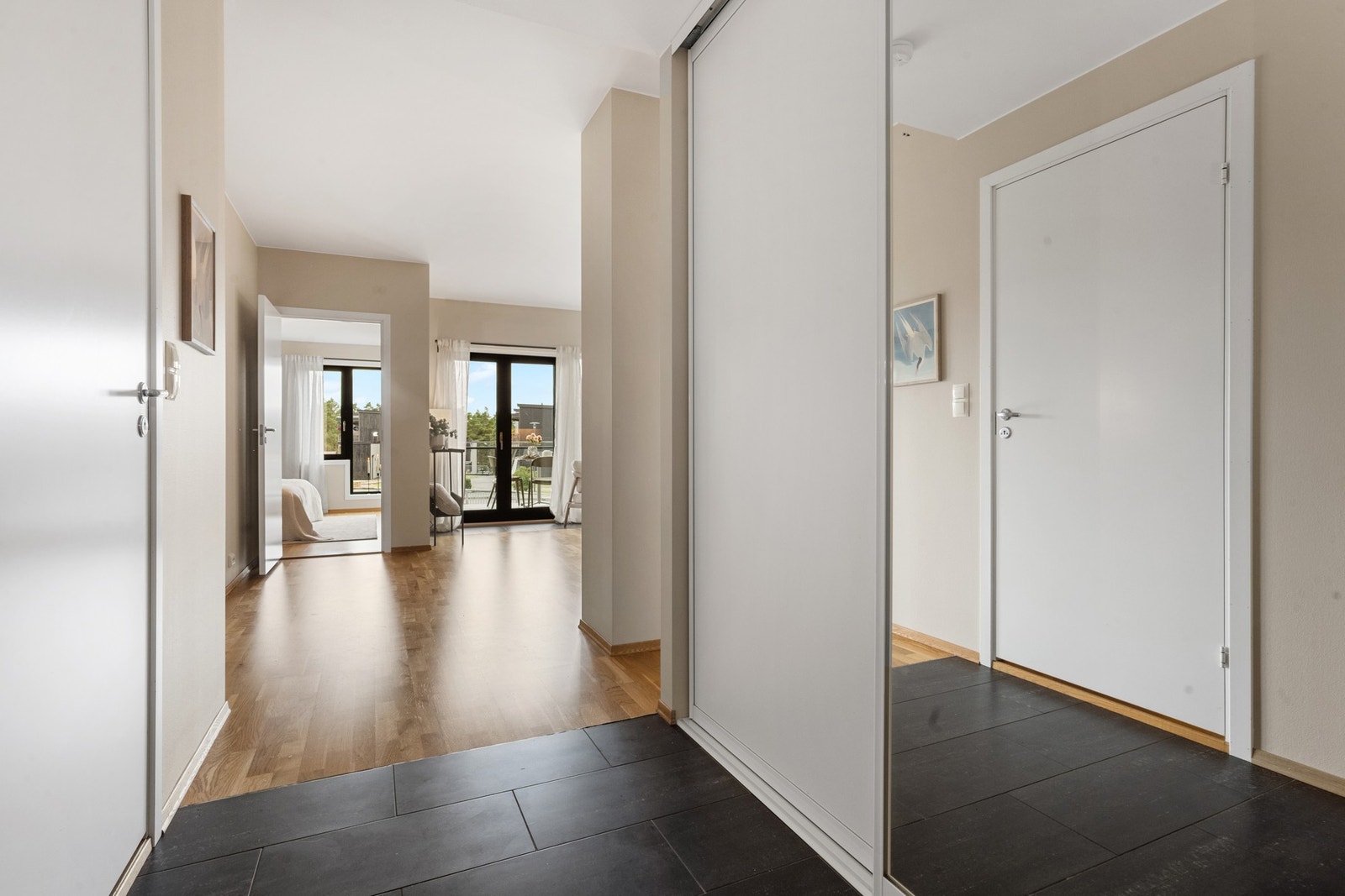 Gangen har flislagt gulv - både praktisk og stilrent, og er utstyrt med en romslig skyvedørsgarderobe for smart oppbevaring. Galleribilde