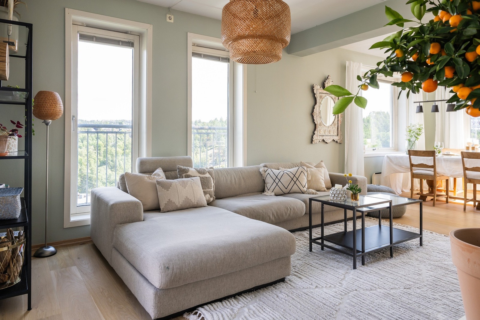 Åpen stue med store vinduer, dempede fargetoner og plass til sofa med tilhørende møblement. Galleribilde