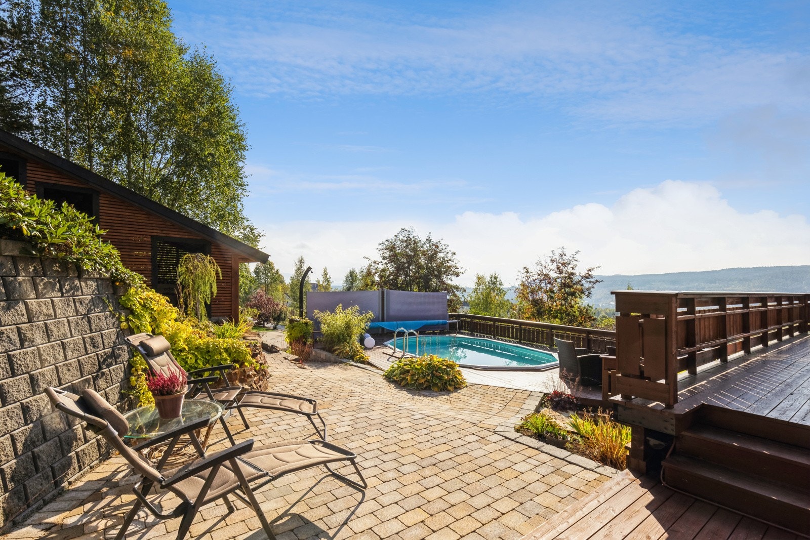 Det er brosteinlagt bakke bak boligen som strekker seg fra bassengområdet til den store terrassen på vestsiden. Galleribilde