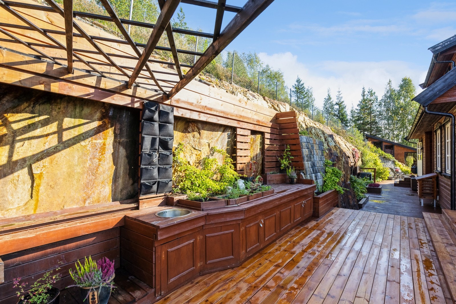 Stor og bred utekjøkken med delvis overbygget pergola tak. Galleribilde