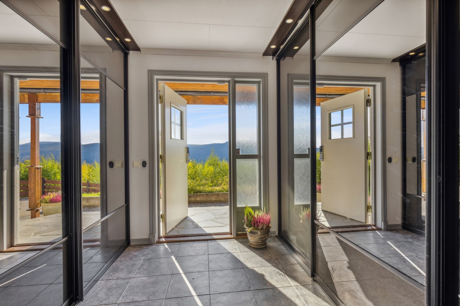 Romslig gang med skyvedørsgarderobe på begge sider med rikelig plass til sko og yttertøy. Galleribilde