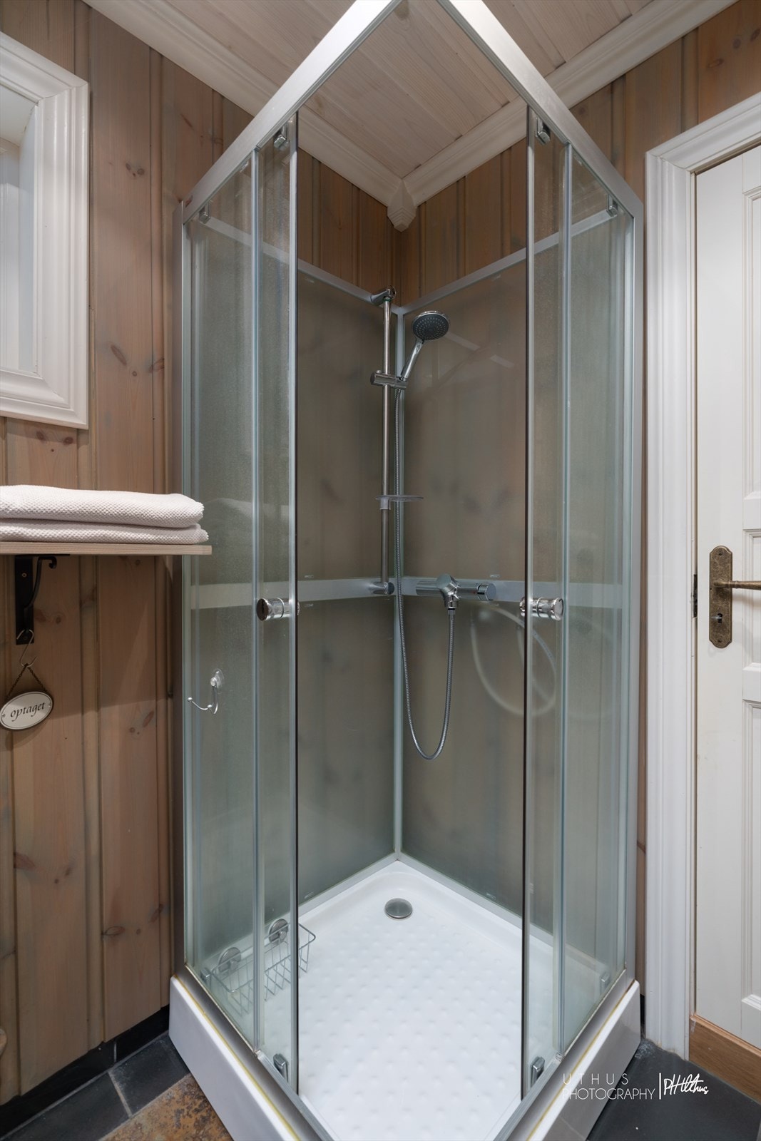 Badet er utstyrt med baderomsinnredning med speilskap og enkel vask, dusjkabinett og toalett Galleribilde