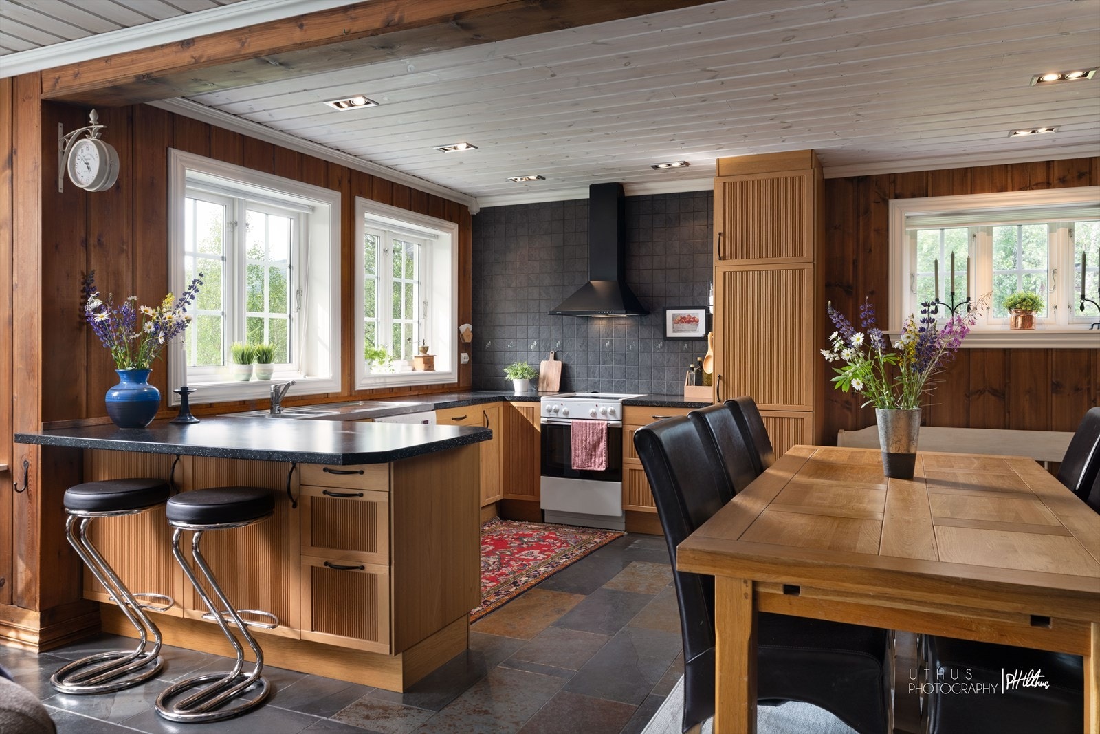 Kjøkkenet har innredning i heltre med profilerte fronter og benkeplate med nedfelt stålvask Galleribilde