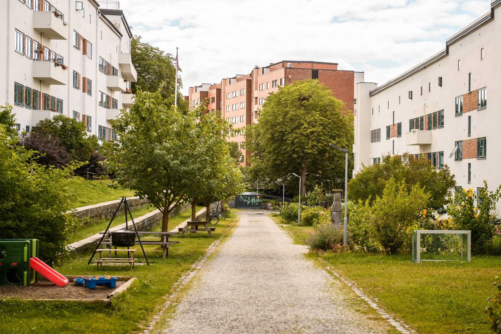 Frodige bakgårdsarealer med sittegrupper og fin beplantning. Galleribilde