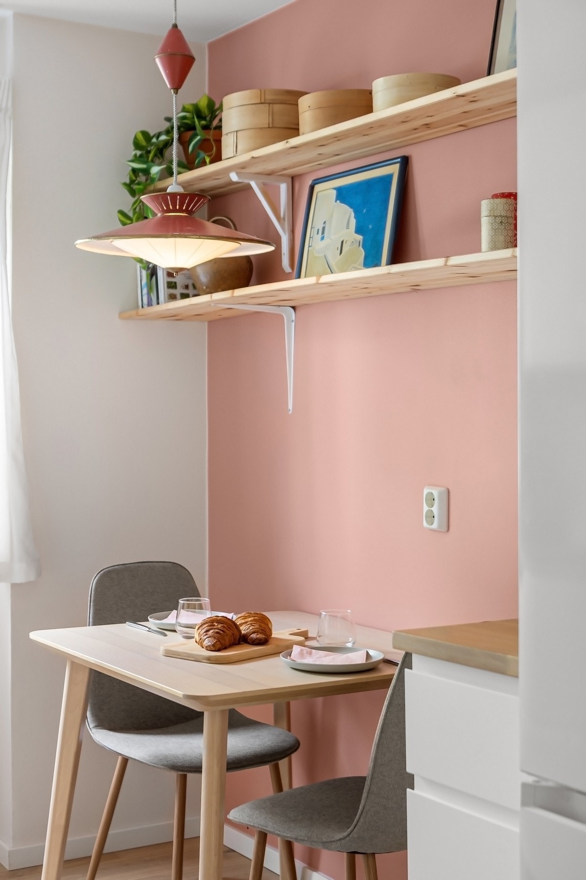 Kjøkkenet har en hyggelig spiseplass. Hyllene på veggen følger boligen. Galleribilde