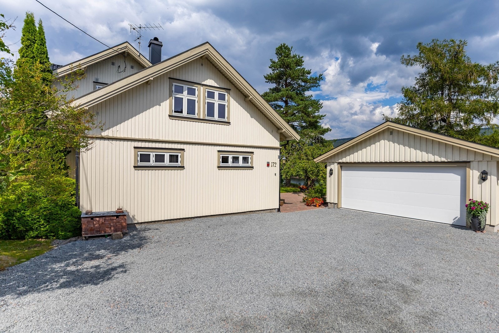 Stor gårdsplass med flere biloppstillingsplasser samt en dobbelgarasje Galleribilde