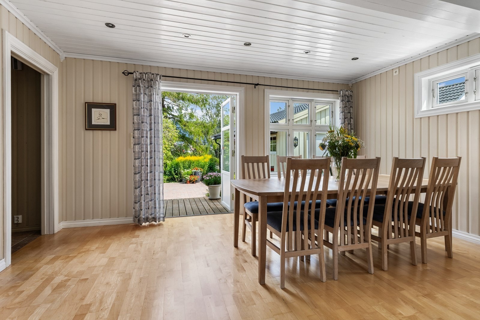 Det er også utgang til bakhagen og terrasse fra stuen Galleribilde