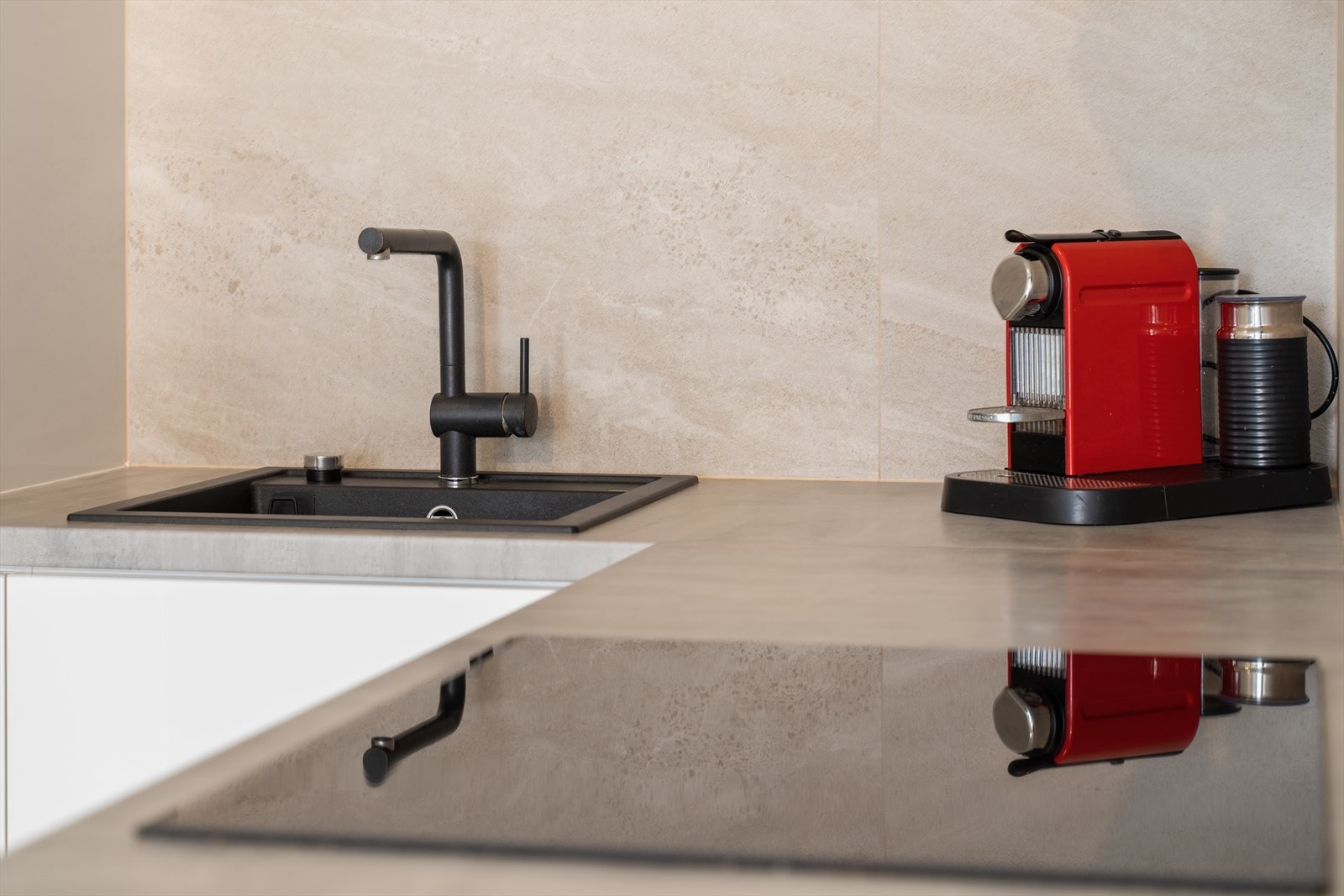 Kjøkkenet holder en moderne stand med glatte fronter og foliert benkeplate. Galleribilde