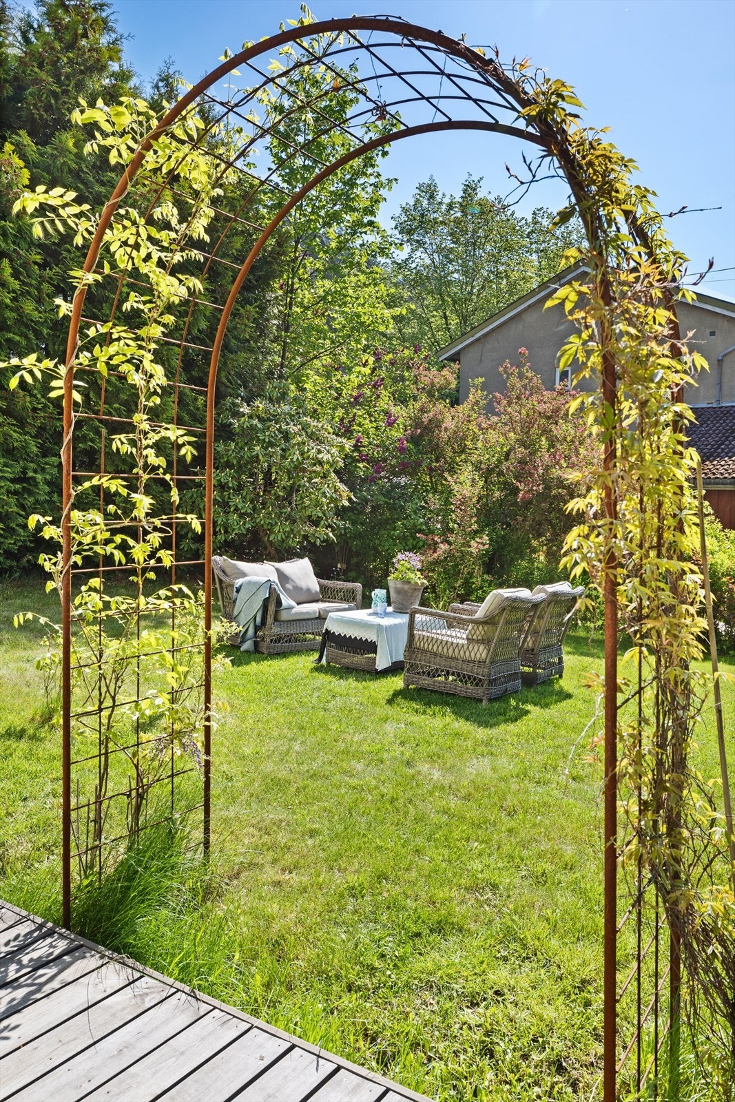 Her finner du god plass til utemøbler, frodige blomsterbusker og en sjarmerende pergola som rammer inn uteplassen. Galleribilde