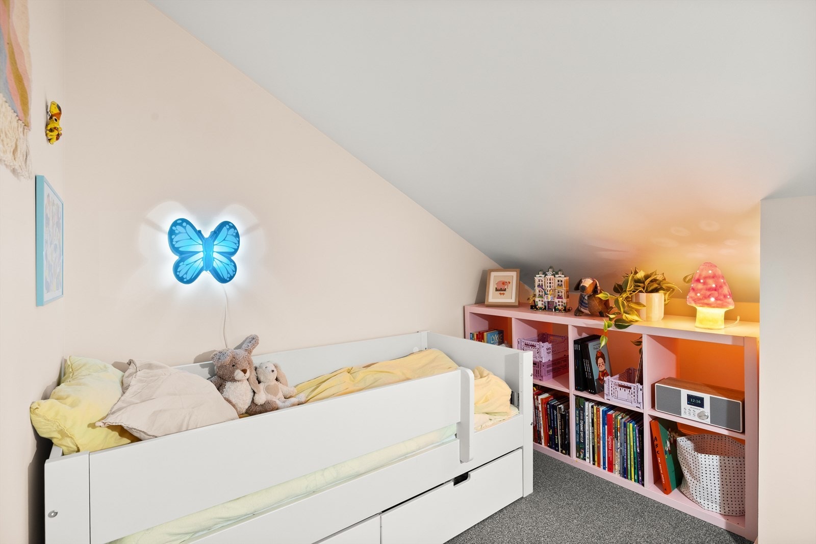 Rommet er smart innredet med seng, oppbevaring og lekne detaljer som skaper en varm og innbydende atmosfære. Galleribilde