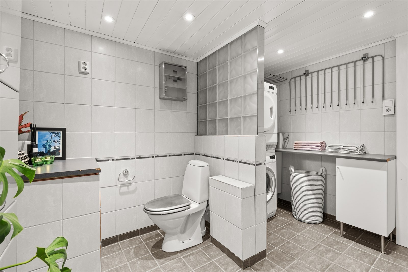 Badet fremstår med mørke gulvfliser og lyse overflater, og downlights i himlingen gir god belysning. Galleribilde