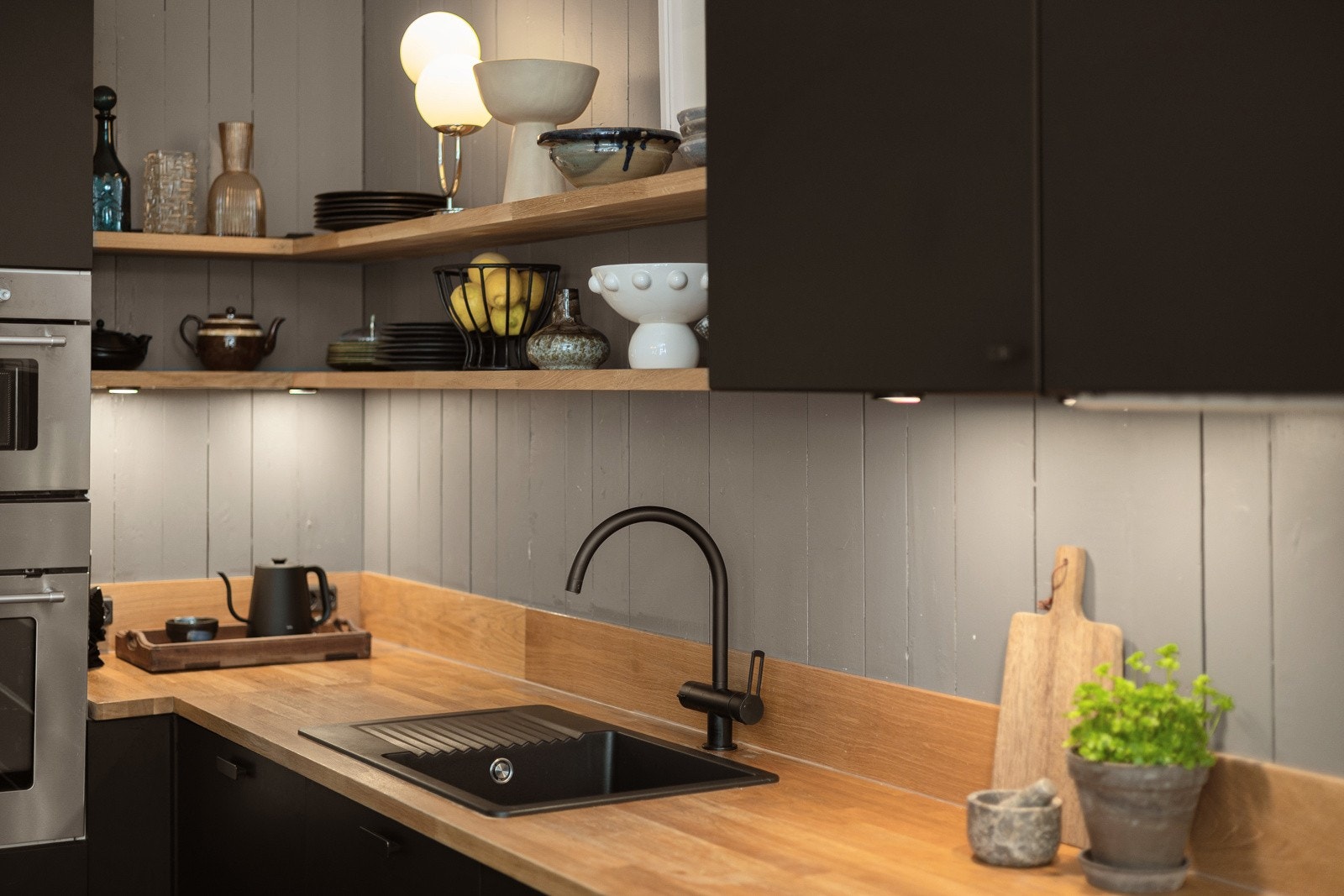 Det er malt original panel mellom overskap og underskap, samt stikkontakter på vegg. Galleribilde