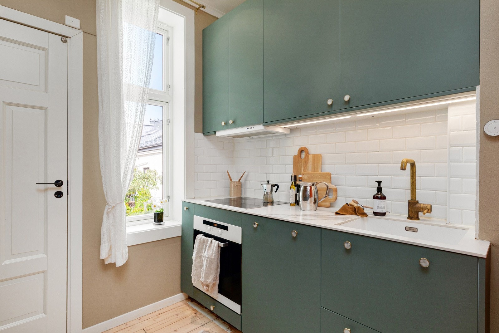 Kjøkkeninnredningen har slette fronter og benkeplate av flis. Galleribilde