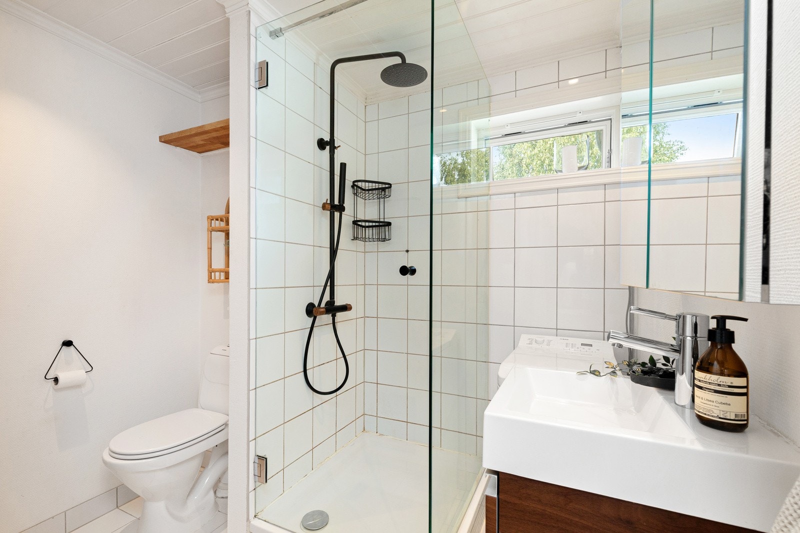 Baderom med flislagt gulv og veggflater utført i malt tapet samt fliser i dusjsonen. Galleribilde