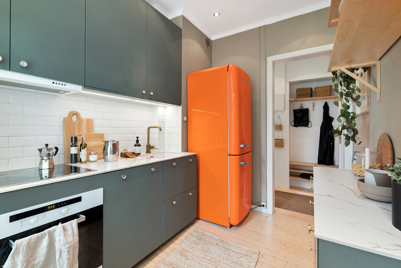 Kjøkkenet er utstyrt med fliser mellom benkeplate og overskap, integrert oppvaskmaskin, komfyr og nedfelt platetopp. Galleribilde