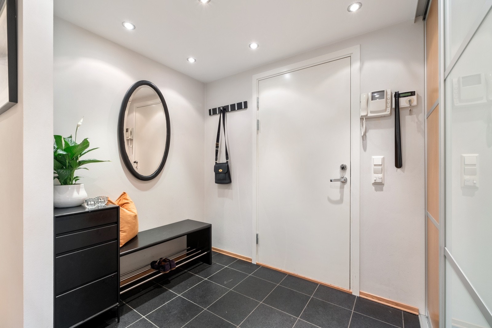 Entréen har en god intern plassering i leiligheten, tilliggende alle våtrommene. Gulvet er lagt med sorte fliser, det er dørtelefon, downlights og skyvedørsgarderobe. Galleribilde