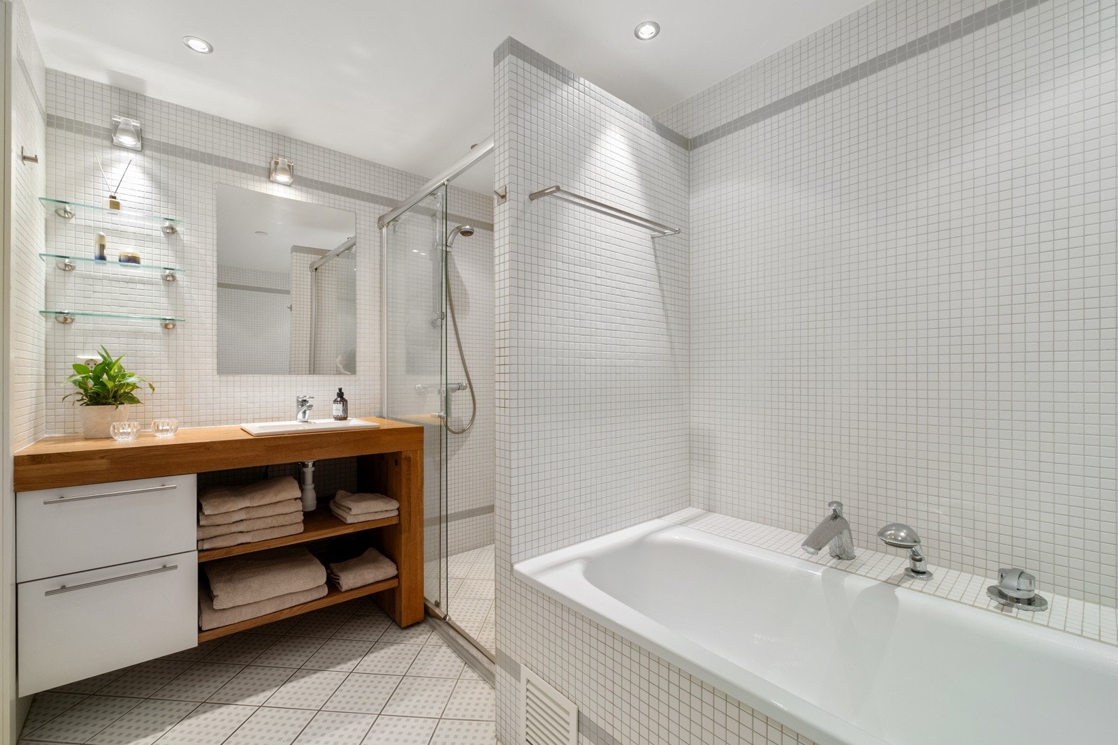 Boligen inneholder et bad, toalettrom og vaskerom, alle fint avskjermet helt innerst i leiligheten. Bildet viser her badet. Galleribilde