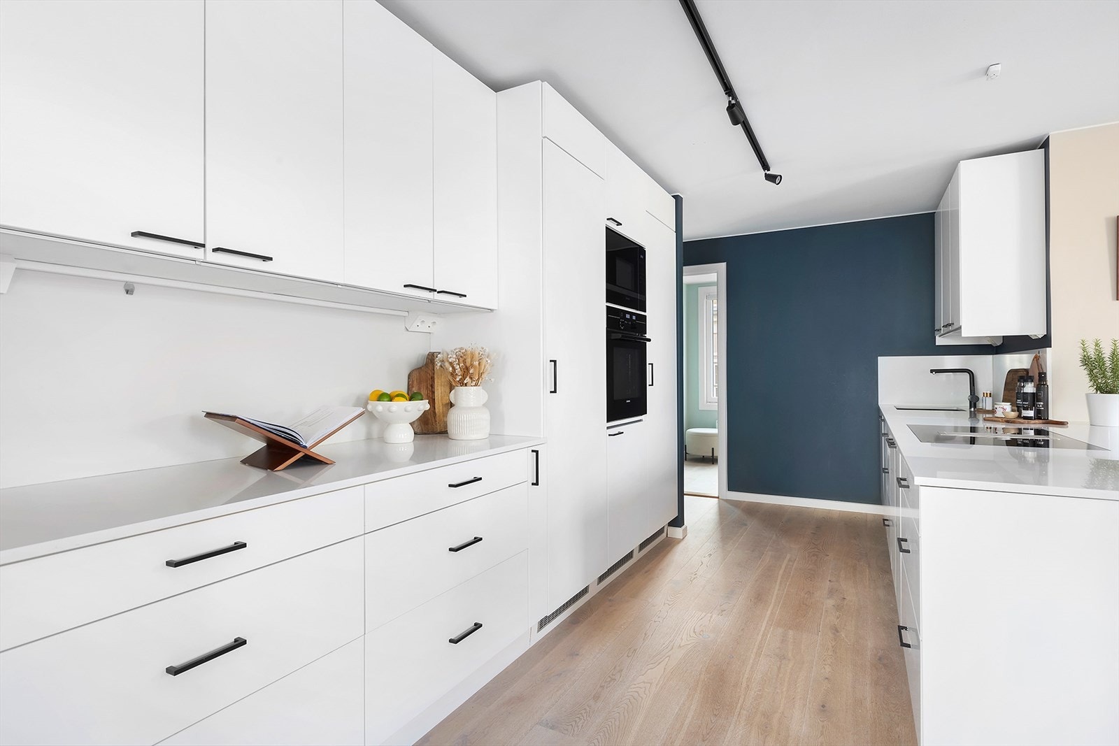 Kjøkkeninnredning i lys og delikat utførelse med benkeplate i steinkompositt Galleribilde