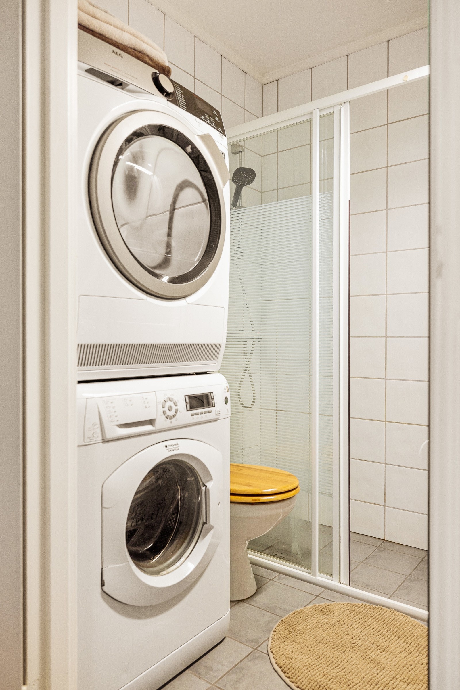 Baderommet er innredet med servant, speil med lys, dusjhjørne, frittstående toalett og opplegg for vaskemaskin. Galleribilde